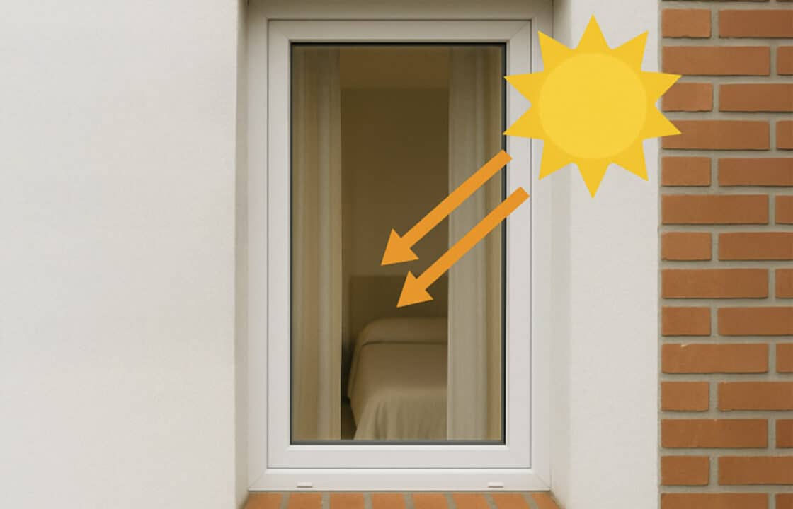 Finestra con infissi in PVC che riflettono il sole, simbolo di isolamento termico ed efficienza energetica per la casa